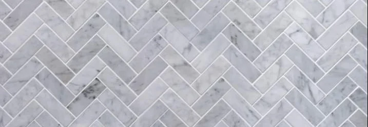 Graue Fliesen im Fischgrätenmuster verlegt.